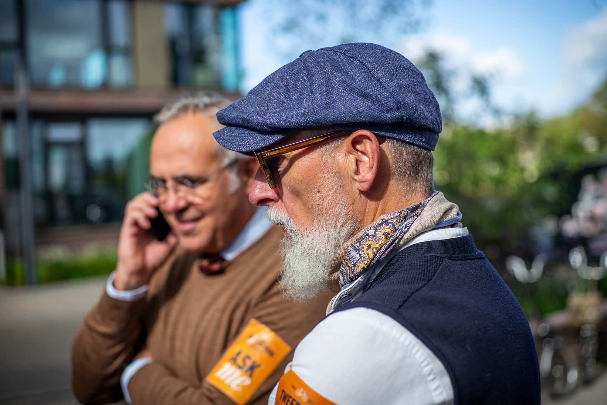 Kurzes Telefonat vor dem Start: zwei Tweed Runner mit Schiebermütze am Treffpunkt Krantine